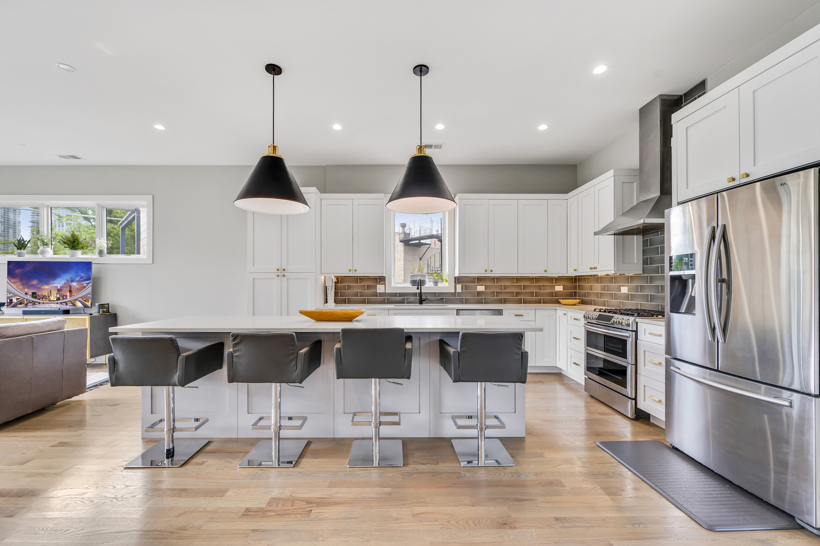 1310 North Cleveland Avenue, Unit 3 Chicago, IL 60610 - Photo 6 of 22 a kitchen with stainless steel appliances kitchen island granite countertop a refrigerator a stove a sink a dining table and chairs with wooden floor