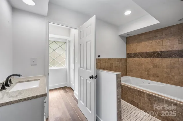 a bathroom with a granite countertop sink a mirror and shower