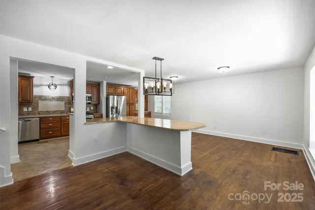 a kitchen with granite countertop a sink cabinets and wooden floor