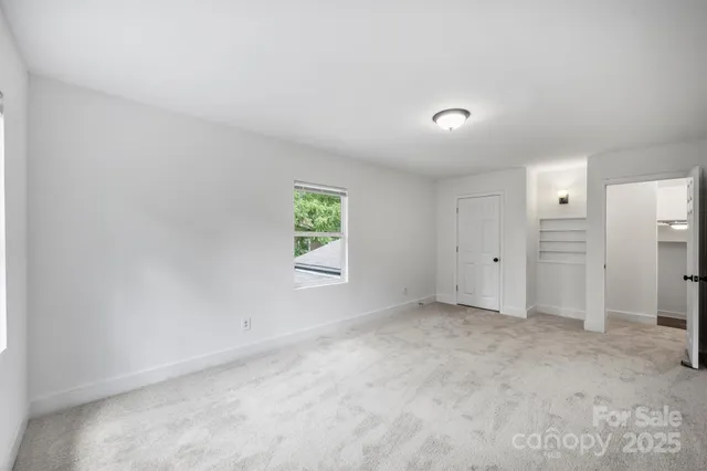 an empty room with windows and closet