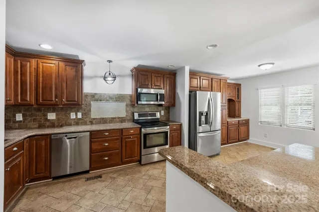 a kitchen with stainless steel appliances granite countertop a refrigerator and a sink