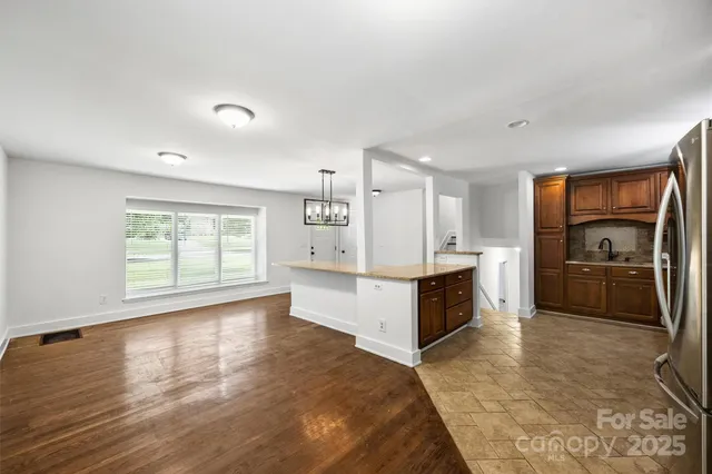 a large white kitchen with a refrigerator a sink dishwasher and a stove