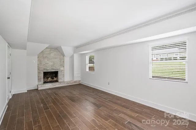 a view of an empty room with a fireplace and a window