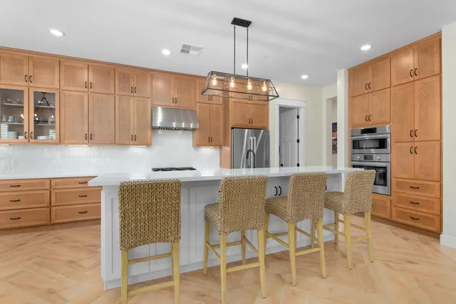 a kitchen with stainless steel appliances granite countertop white cabinets and a stove