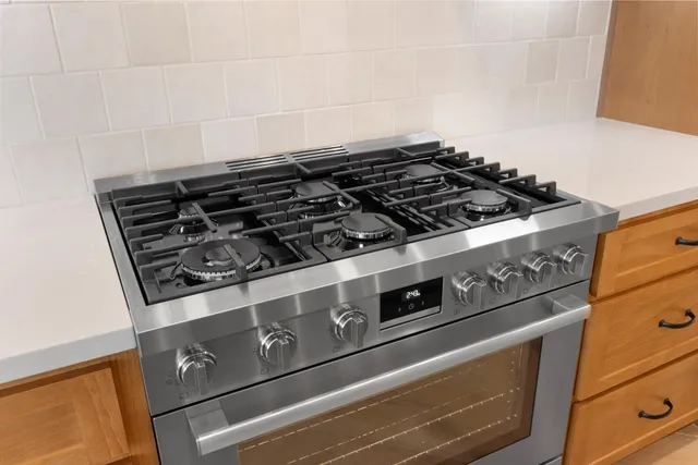a kitchen with stainless steel appliances a sink stove and cabinets