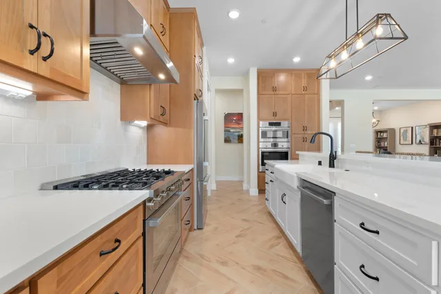 a kitchen with granite countertop white cabinets and stainless steel appliances