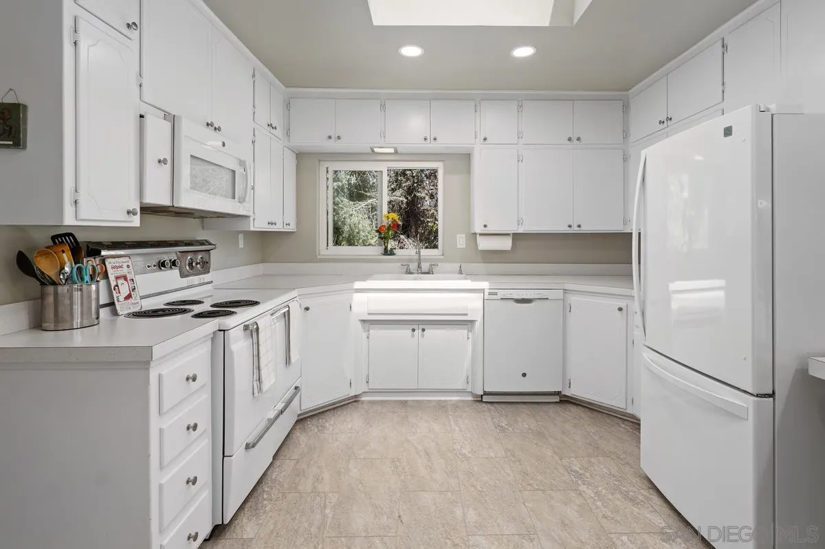 4744 Resmar Road La Mesa, CA 91941 - Photo 7 of 58 a kitchen with white cabinets stainless steel appliances and a refrigerator