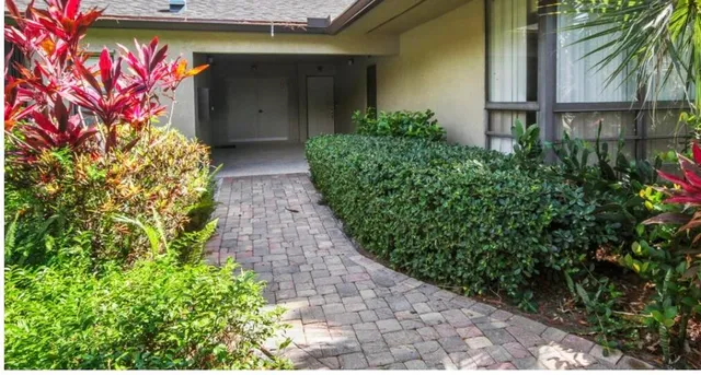 a front view of a house with plants