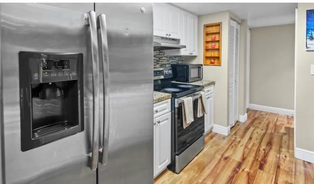 a kitchen with stainless steel appliances granite countertop a refrigerator and a stove
