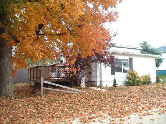 a wooden bench sitting in front of a house