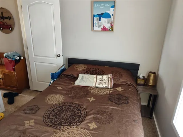 a large bed sitting in a bedroom next to a window