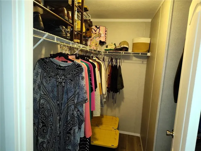 a view of walk in closet with clothes and shoes
