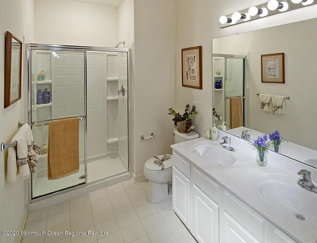a bathroom with a double vanity sink toilet and shower