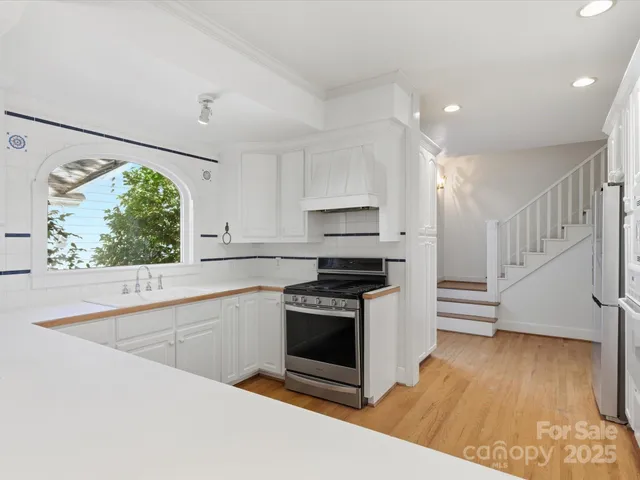 a kitchen with stainless steel appliances a stove a sink and a refrigerator