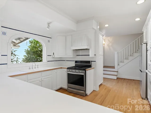 a kitchen with stainless steel appliances granite countertop a stove a sink and a microwave