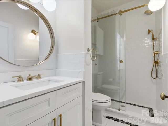 a bathroom with a sink a toilet and shower