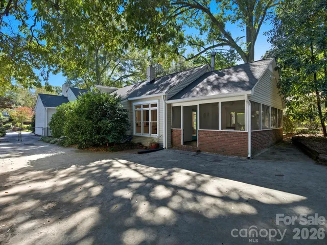 a view of a yard in front of a house with large tree