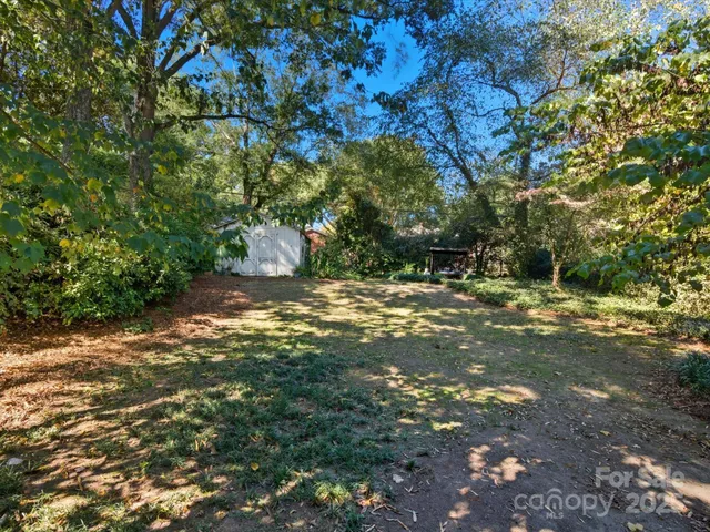 an aerial view of residential houses with outdoor space and trees