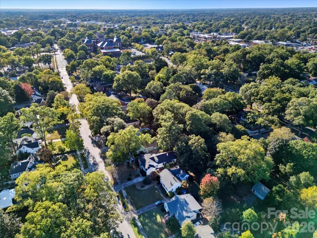 an aerial view of residential houses with outdoor space and trees