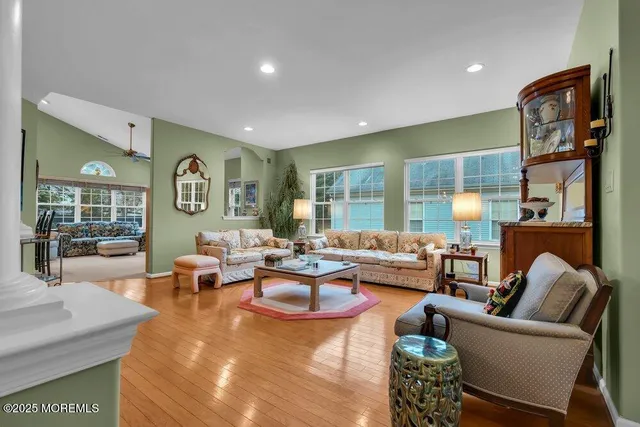a living room with furniture kitchen view and a flat screen tv