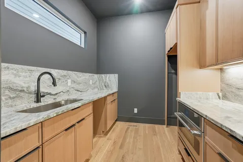 a kitchen with a sink and a wooden floor