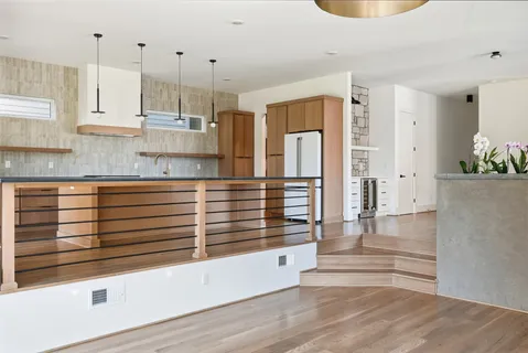 a view of a kitchen with kitchen island a sink stainless steel appliances and cabinets