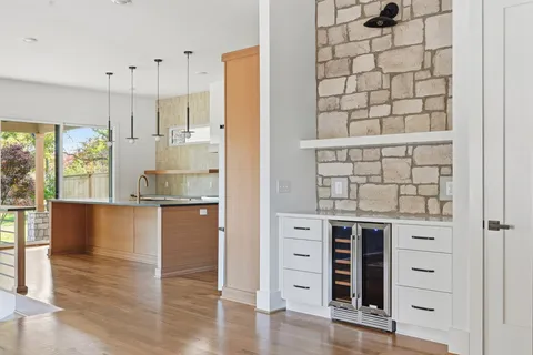 a kitchen with stainless steel appliances wooden floor and window