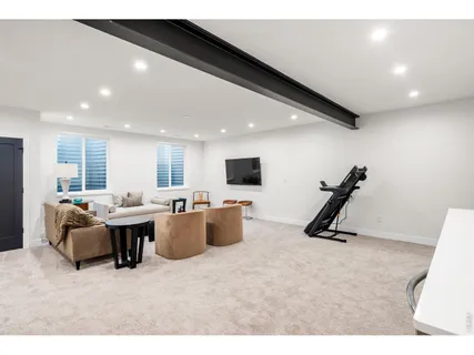 a living room with furniture a flat screen tv and a window