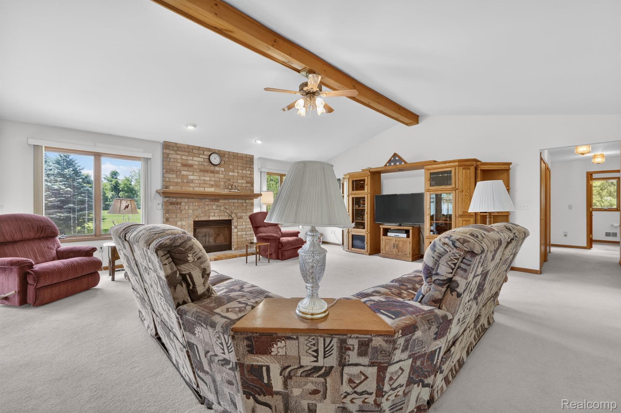 8558 37 Mile Road Romeo, MI 48065 - Photo 6 of 29 Spacious living area featuring a vaulted ceiling with exposed wood beams and a ceiling fan