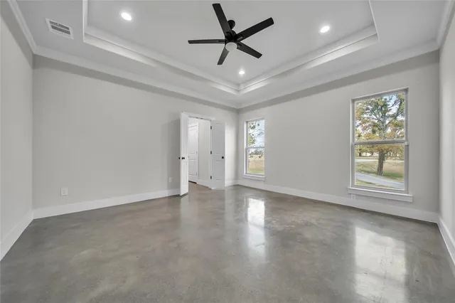 an empty room with windows and a ceiling fan