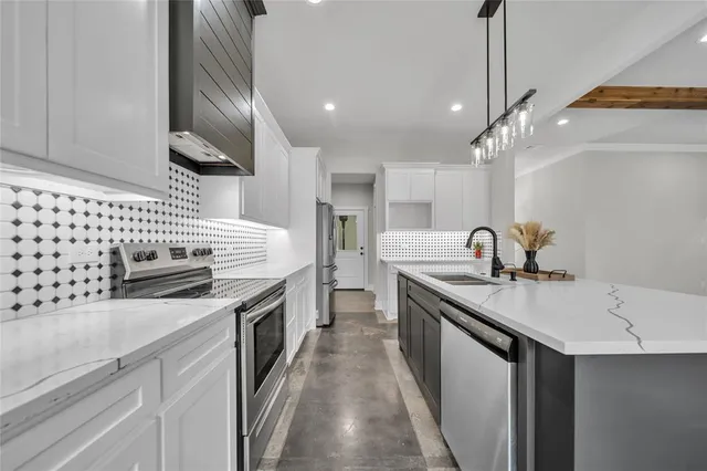 a kitchen with stainless steel appliances granite countertop a sink a stove and a wooden floors