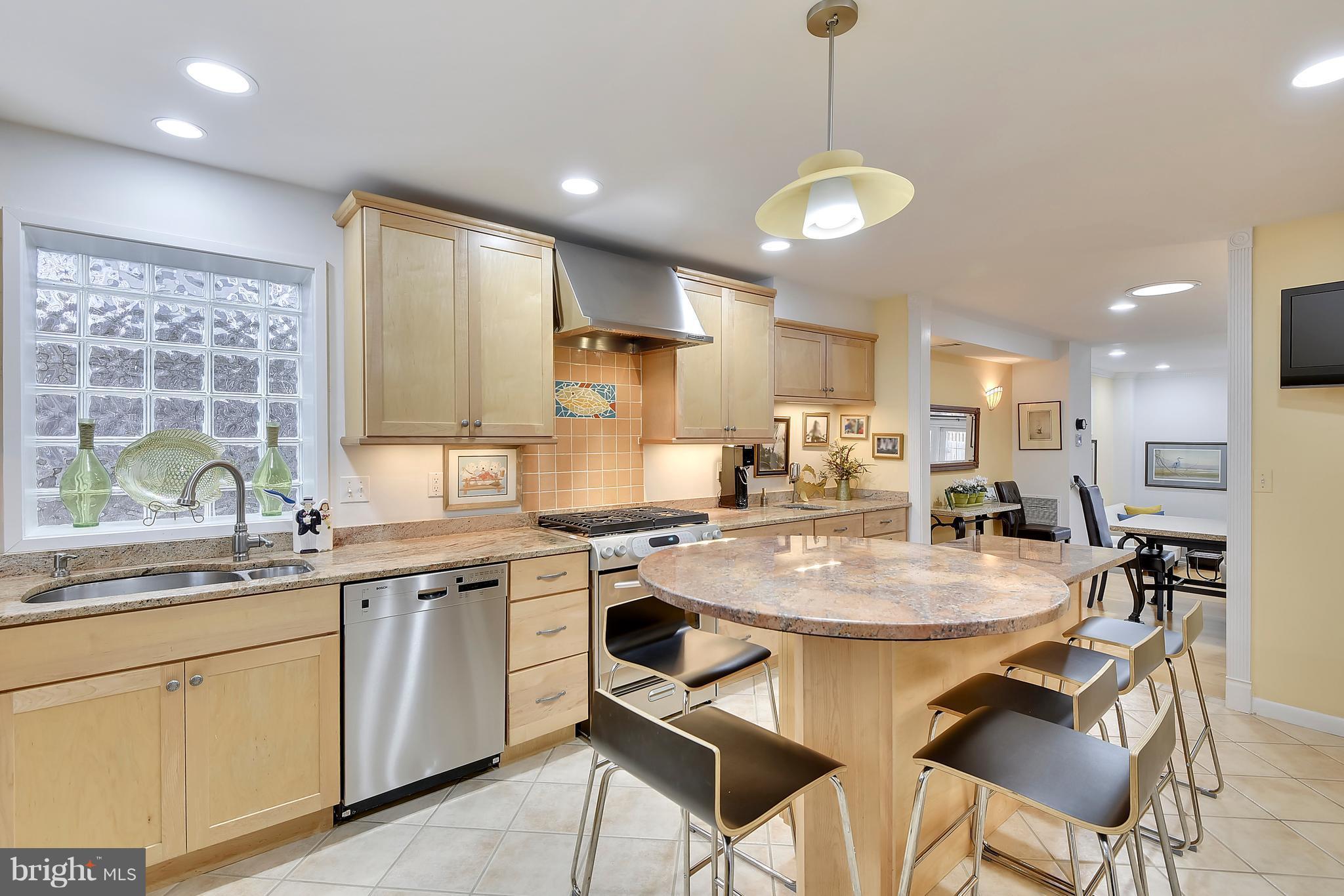 309 Fourth Street Annapolis, MD 21403 - Photo 6 of 30 a kitchen with stainless steel appliances granite countertop a stove a sink a refrigerator island white cabinets with a dining table and chairs
