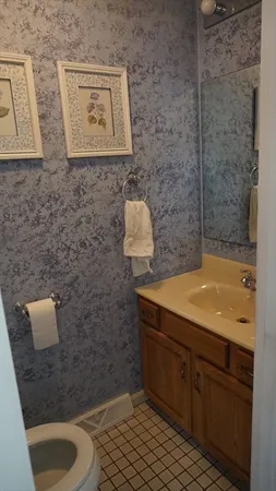 a bathroom with a granite countertop sink a toilet and mirror