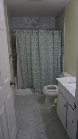 a bathroom with a toilet a sink and shower