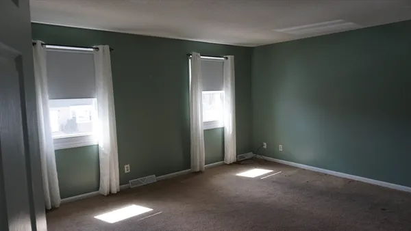 an empty room with windows and closet
