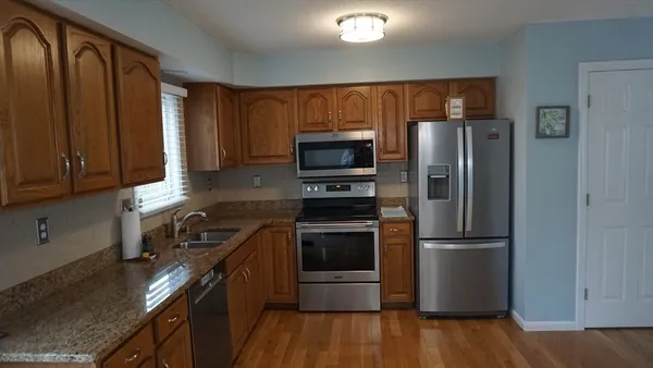 a kitchen with stainless steel appliances granite countertop a refrigerator stove and microwave