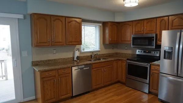 a kitchen with stainless steel appliances granite countertop a stove a sink dishwasher and a refrigerator