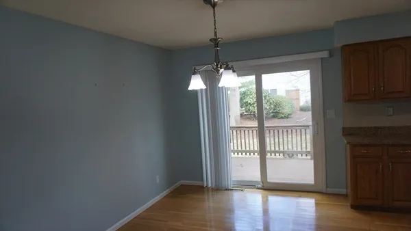 a view of hallway with wooden floor and chandelier