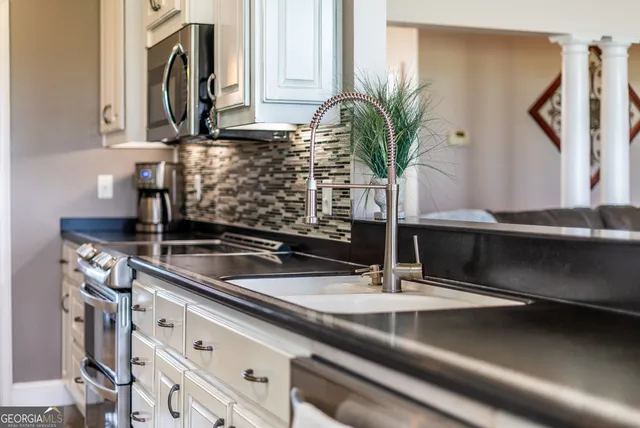 a kitchen with stainless steel appliances granite countertop a refrigerator and a stove