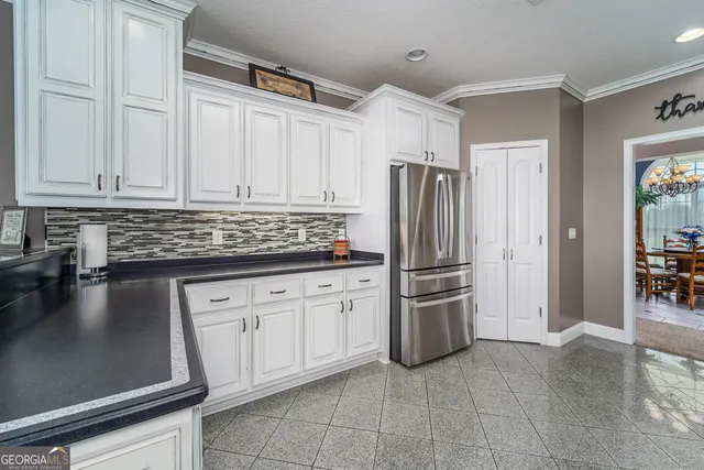 a large kitchen with stainless steel appliances and white cabinets