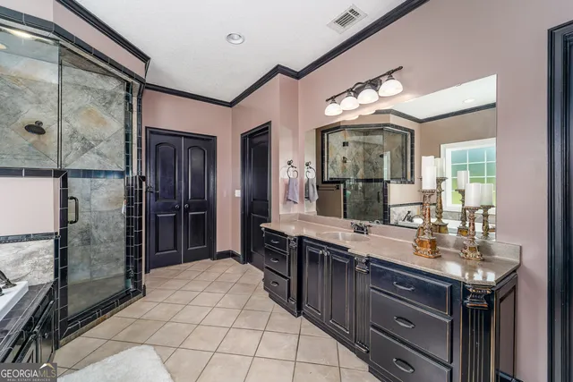 a spacious bedroom with a bed a couch and a chandelier