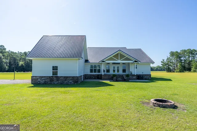 a view of a house with a yard and a large tree