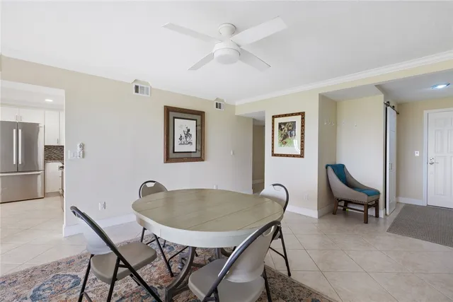 a kitchen with stainless steel appliances granite countertop a refrigerator a sink a stove and white cabinets with wooden floor