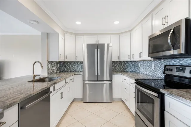 a kitchen with stainless steel appliances granite countertop a stove microwave and refrigerator