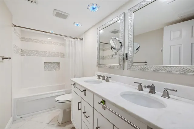 a bathroom with a granite countertop sink toilet a large mirror a shower and