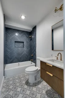a bathroom with a granite countertop sink a toilet and shower