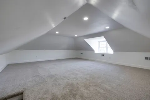 a backyard of a house with large trees and plants