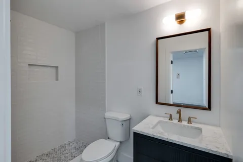a bathroom with a toilet sink and mirror