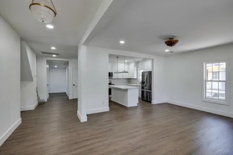 a view of a kitchen with a sink and dishwasher a refrigerator with wooden floor