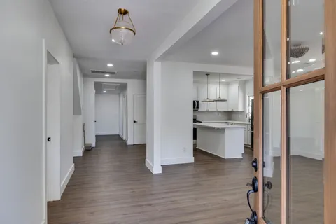 a view of a kitchen with wooden floor and a window